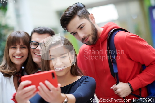 Image of Group of multiethnic teenagers taking a selfie in school