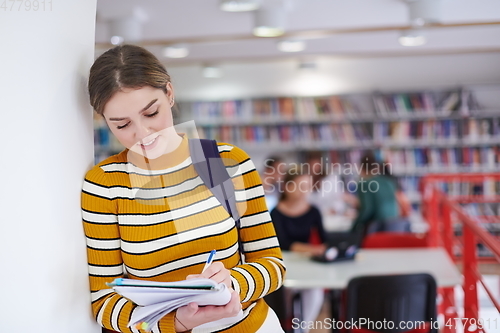 Image of the student uses a notebook and a school library