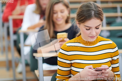 Image of famel students using smartphone in classroom