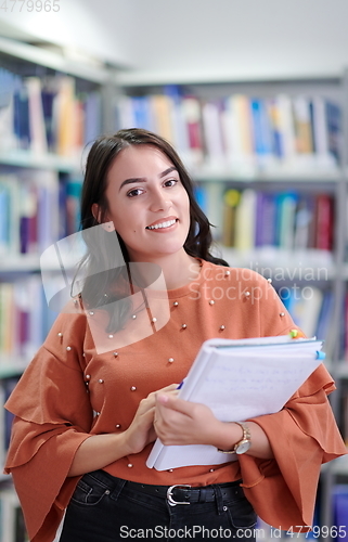 Image of the student uses a notebook and a school library