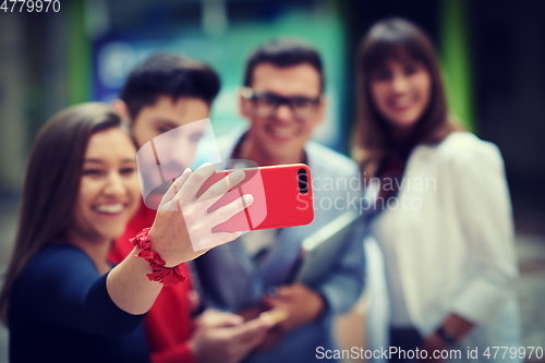 Image of Group of multiethnic teenagers taking a selfie in school