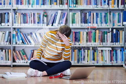 Image of the student uses a notebook and a school library