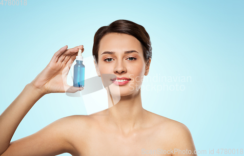 Image of beautiful young woman with bottle of serum