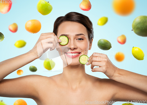 Image of beautiful woman making eye mask of cucumbers