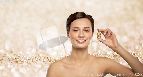 Image of beautiful young woman with gold facial mask