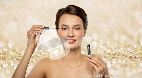 Image of beautiful woman applying mascara