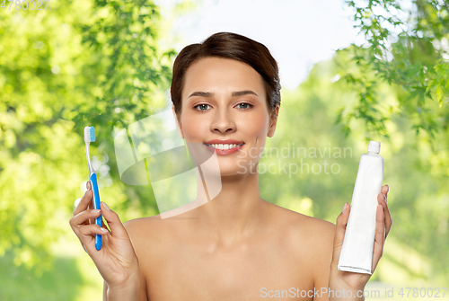 Image of smiling woman with toothbrush cleaning teeth