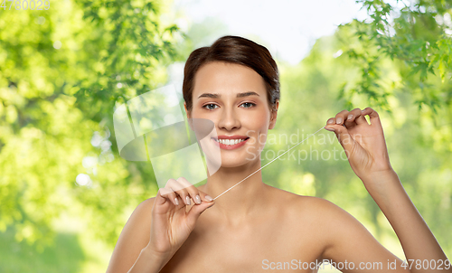 Image of happy young woman with dental floss cleaning teeth