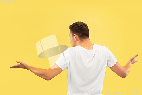 Image of Caucasian young man\'s half-length portrait on yellow background