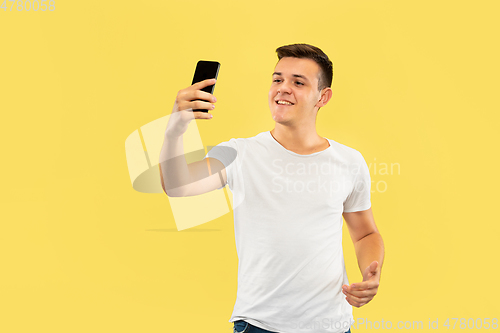 Image of Caucasian young man\'s half-length portrait on yellow background