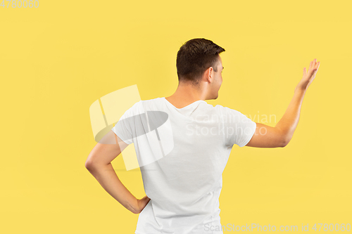 Image of Caucasian young man\'s half-length portrait on yellow background