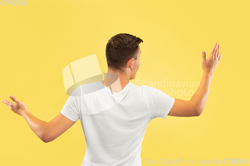 Image of Caucasian young man\'s half-length portrait on yellow background