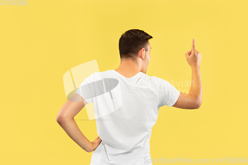 Image of Caucasian young man\'s half-length portrait on yellow background