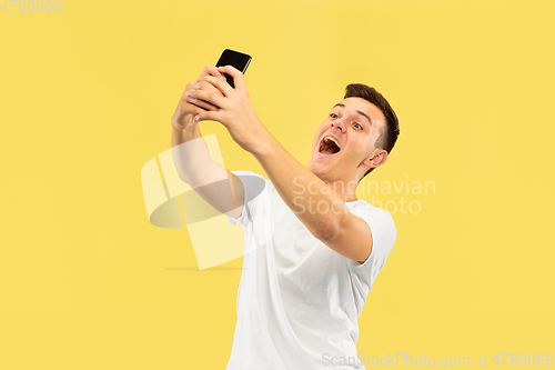 Image of Caucasian young man\'s half-length portrait on yellow background