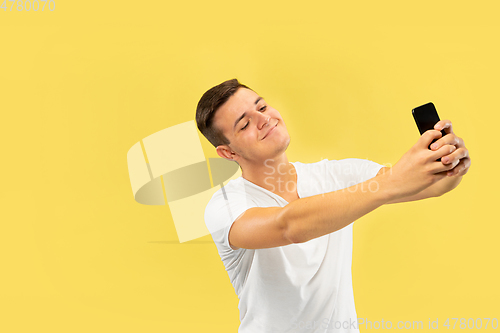 Image of Caucasian young man\'s half-length portrait on yellow background