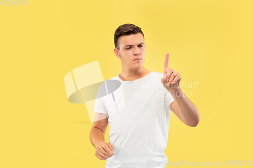 Image of Caucasian young man\'s half-length portrait on yellow background