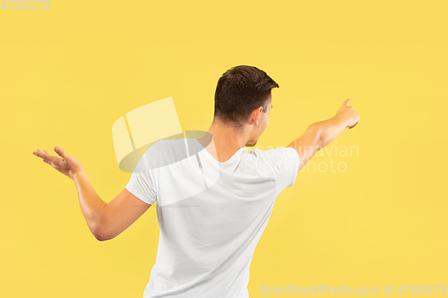Image of Caucasian young man\'s half-length portrait on yellow background