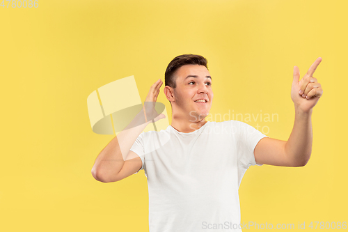 Image of Caucasian young man\'s half-length portrait on yellow background