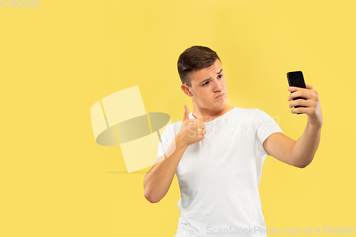 Image of Caucasian young man\'s half-length portrait on yellow background