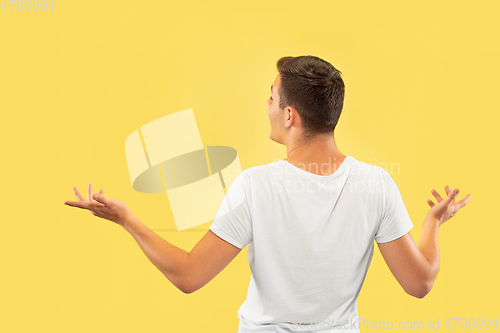 Image of Caucasian young man\'s half-length portrait on yellow background