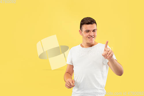 Image of Caucasian young man\'s half-length portrait on yellow background