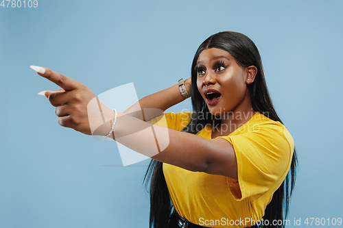 Image of African-american young woman\'s half-length portrait on blue background