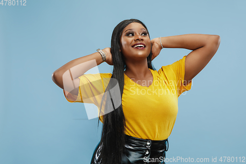 Image of African-american young woman\'s half-length portrait on blue background