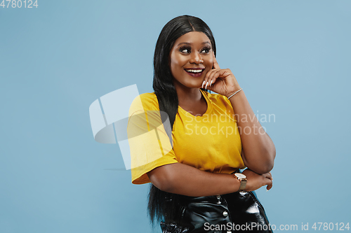 Image of African-american young woman\'s half-length portrait on blue background