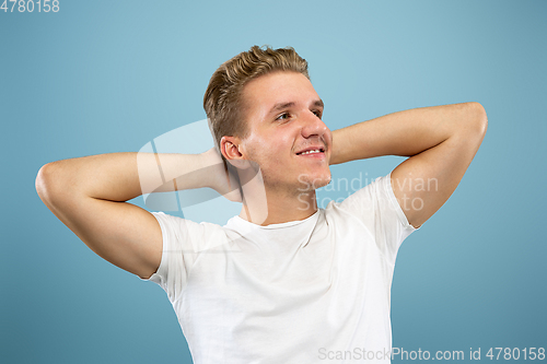 Image of Caucasian young man\'s half-length portrait on blue background