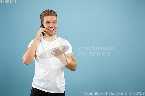 Image of Caucasian young man\'s half-length portrait on blue background