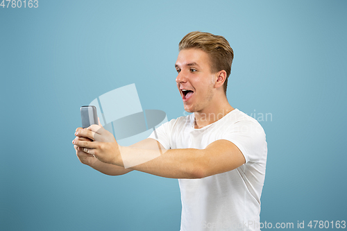 Image of Caucasian young man\'s half-length portrait on blue background