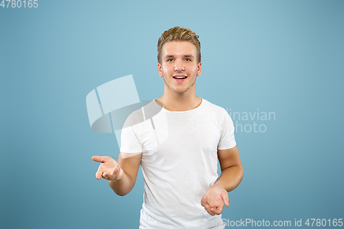 Image of Caucasian young man\'s half-length portrait on blue background