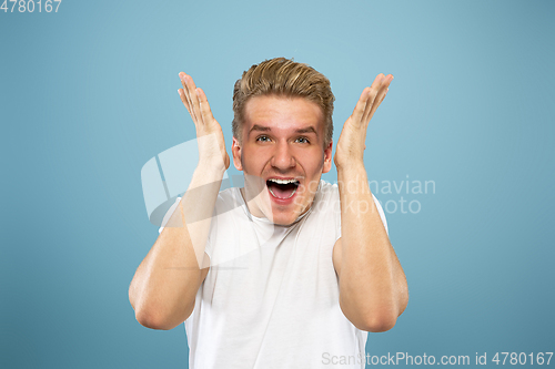 Image of Caucasian young man\'s half-length portrait on blue background
