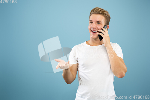 Image of Caucasian young man\'s half-length portrait on blue background