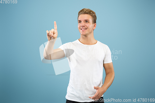 Image of Caucasian young man\'s half-length portrait on blue background