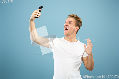 Image of Caucasian young man\'s half-length portrait on blue background