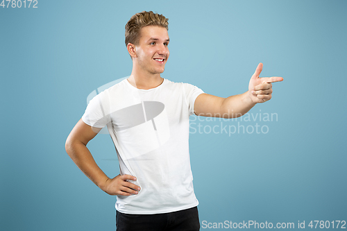 Image of Caucasian young man\'s half-length portrait on blue background