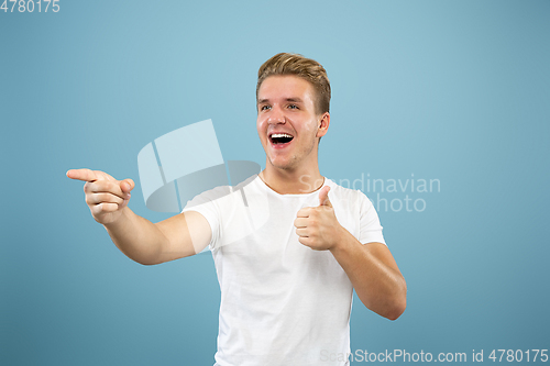 Image of Caucasian young man\'s half-length portrait on blue background