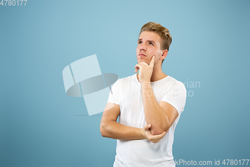 Image of Caucasian young man\'s half-length portrait on blue background