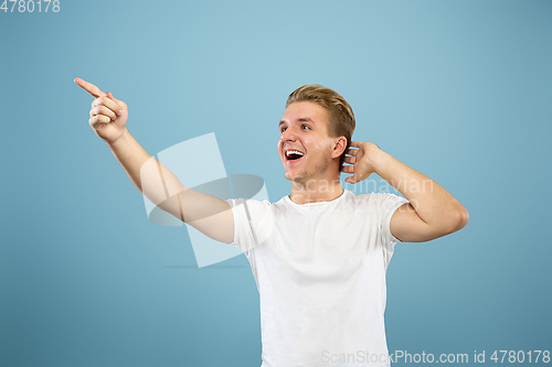 Image of Caucasian young man\'s half-length portrait on blue background