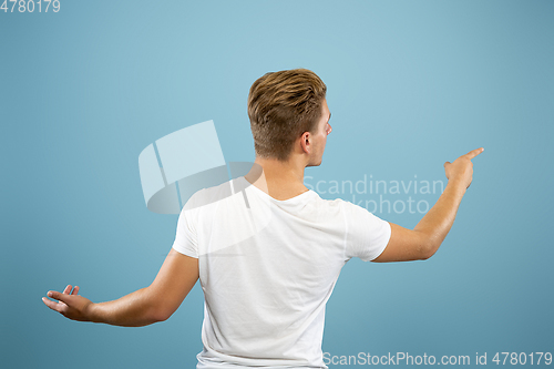 Image of Caucasian young man\'s half-length portrait on blue background