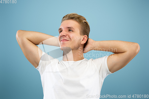Image of Caucasian young man\'s half-length portrait on blue background