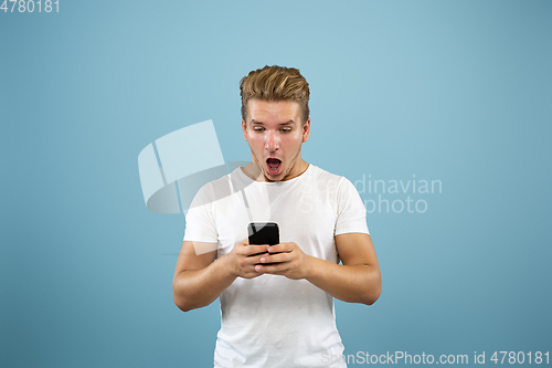 Image of Caucasian young man\'s half-length portrait on blue background