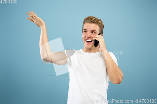 Image of Caucasian young man\'s half-length portrait on blue background