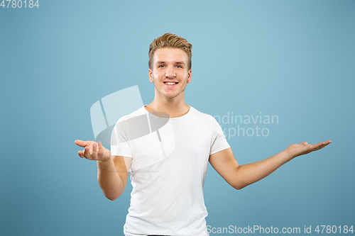 Image of Caucasian young man\'s half-length portrait on blue background