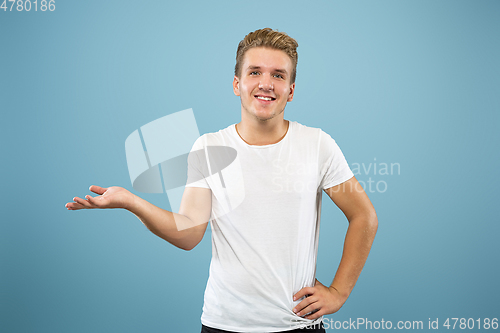 Image of Caucasian young man\'s half-length portrait on blue background