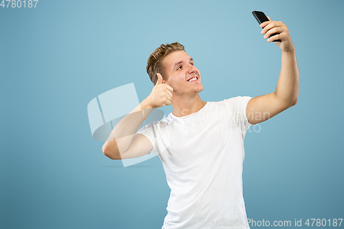 Image of Caucasian young man\'s half-length portrait on blue background