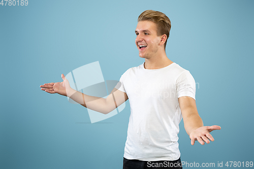 Image of Caucasian young man\'s half-length portrait on blue background