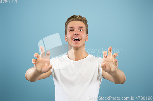 Image of Caucasian young man\'s half-length portrait on blue background