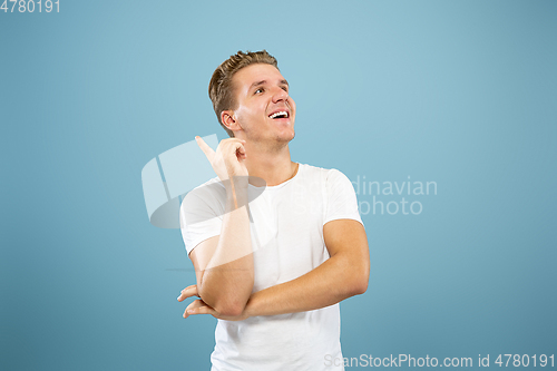 Image of Caucasian young man\'s half-length portrait on blue background